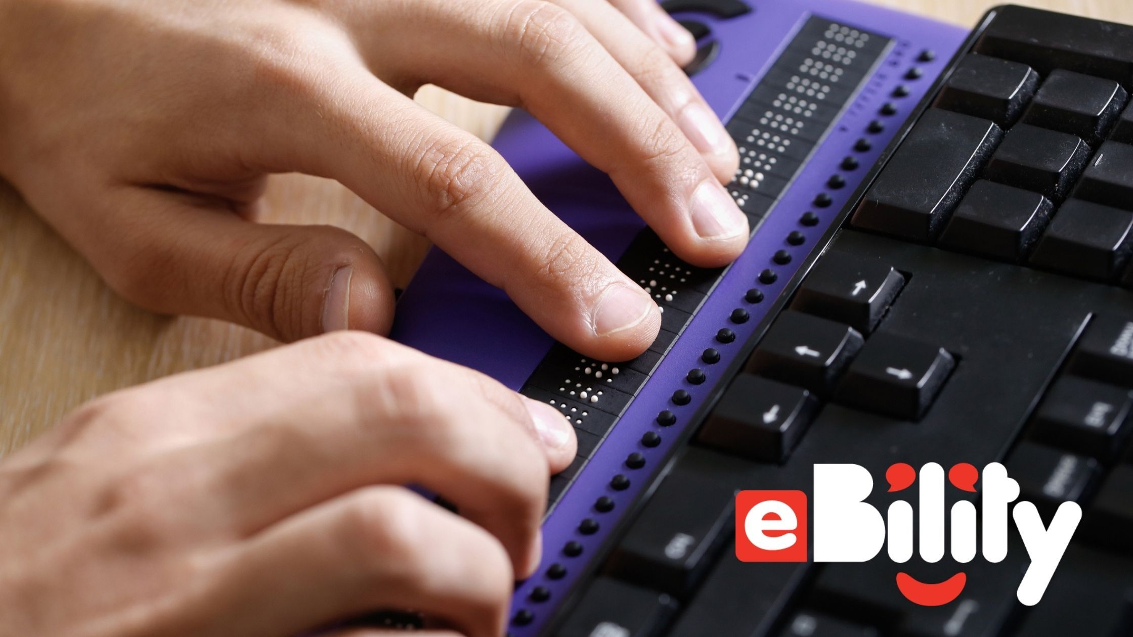 hands typing on a braille keyboard. eBility.